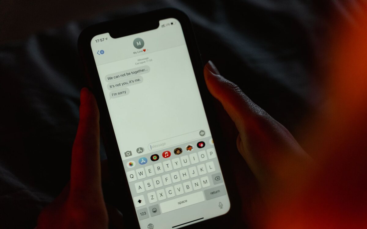 Mãos digitando uma mensagem na tela do celular